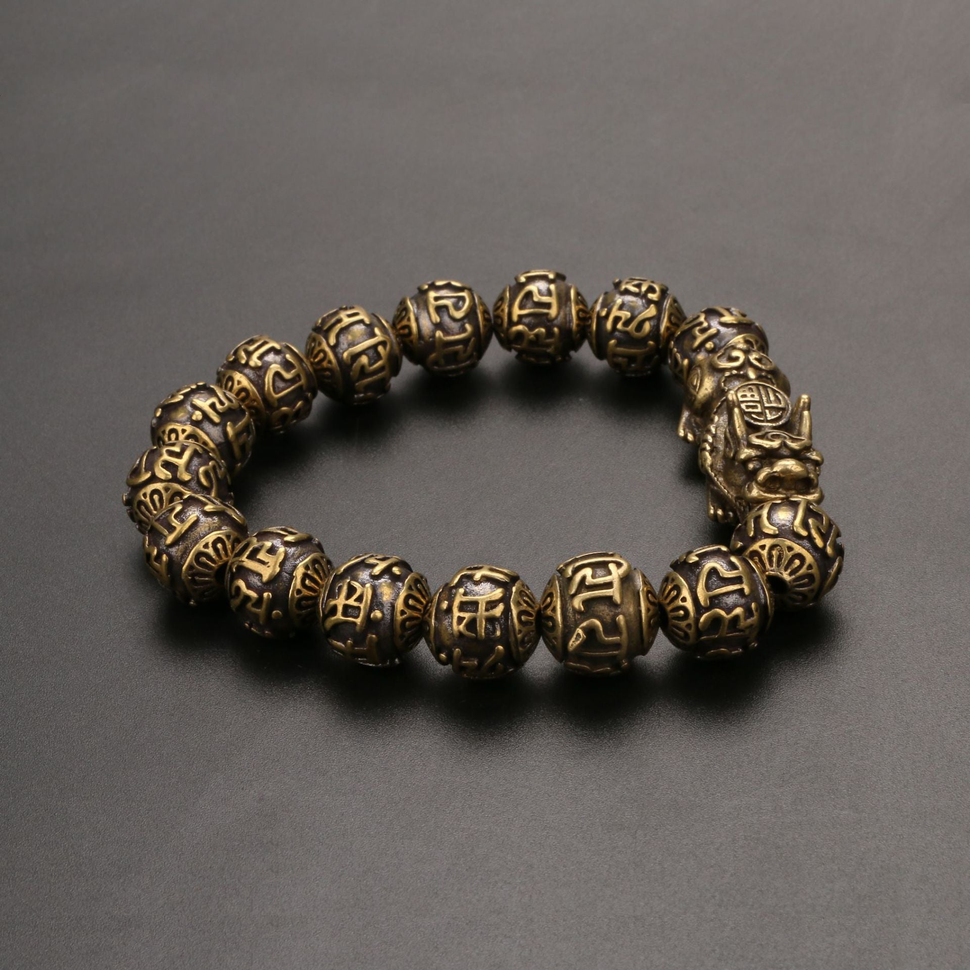 Brass mala bracelet for men featuring a Pi Yao charm for wealth and mantra beads for protection.