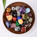 A beautifully curated collection of tumbled gemstones in various colors, presented as a versatile tool for energy work and spiritual well-being.