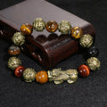 Black obsidian beads of the Pi Yao bracelet engraved with the sacred Om Mani Padme Hum mantra.