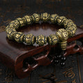 Close-up of the individual antique brass and black obsidian beads on the Om Mani Padme Hum bracelet.