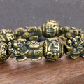 Close-up detail of the intricately carved Pi Yao charm on the solid brass wealth bracelet.