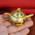 Polished brass spinning teapot, a thoughtful and novel gift for gamers, combining a fidget toy with a luck-bringing talisman.