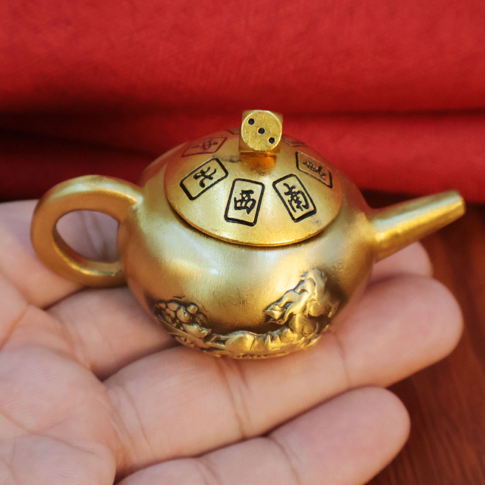 Polished brass spinning teapot, a thoughtful and novel gift for gamers, combining a fidget toy with a luck-bringing talisman.