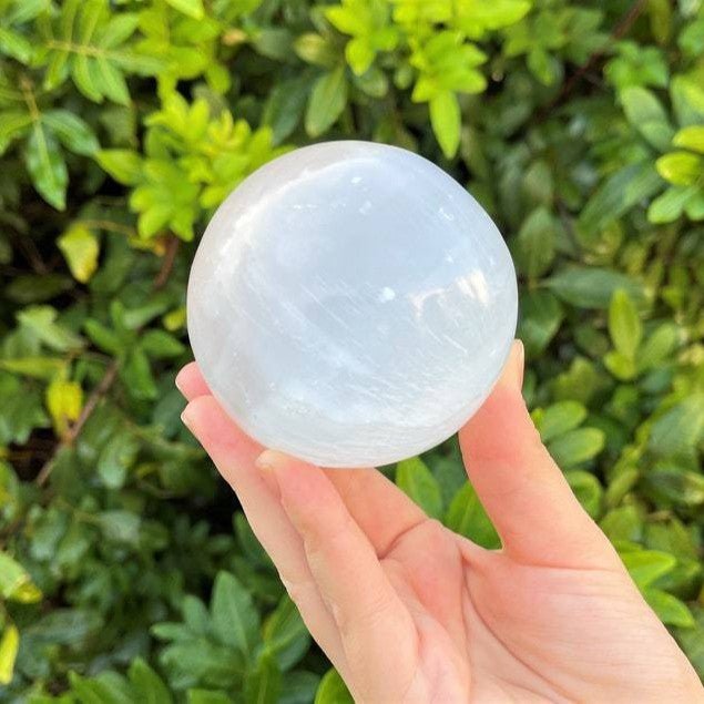 An elegant Moroccan Selenite crystal ball, serving as a powerful energy tool and a beautiful centerpiece for any room.