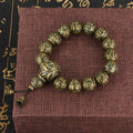 Single strand Om Mani Padme Hum bracelet with antique brass and black obsidian beads.