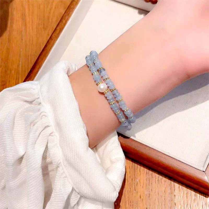 A bracelet combining rose quartz for love with aquamarine for communication, set in a double wrap design.