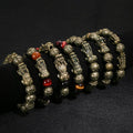 Detailed craftsmanship of the black obsidian Pi Yao bracelet, showing the engraved mantra and mystic knot.